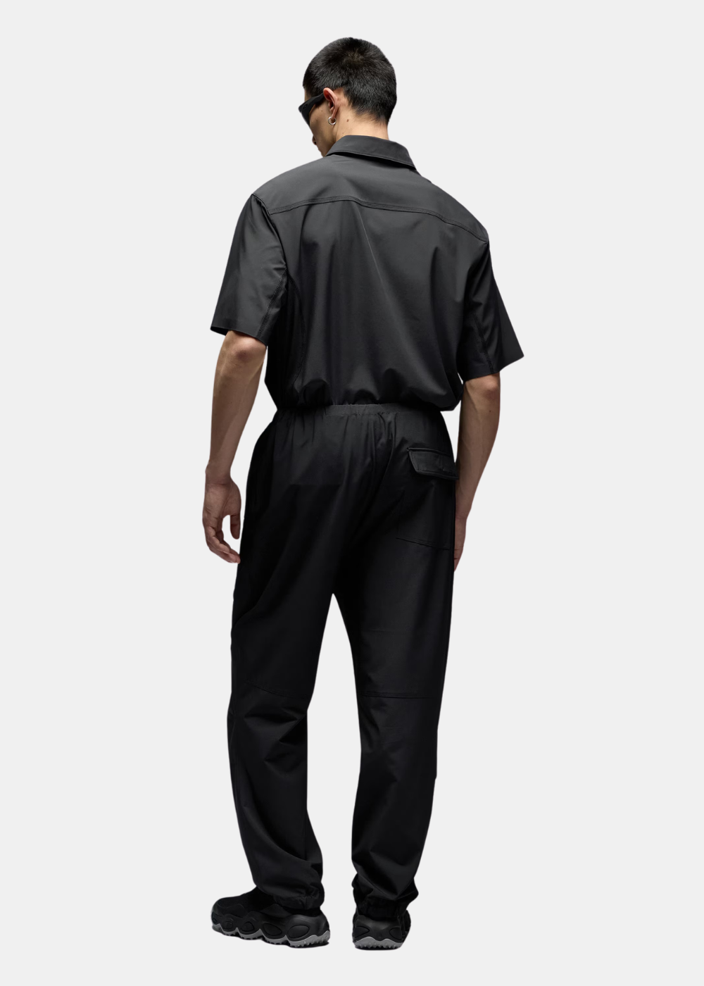 Vue arrière du pantalon technique noir Oakley porté, montrant la poche arrière et la coupe.