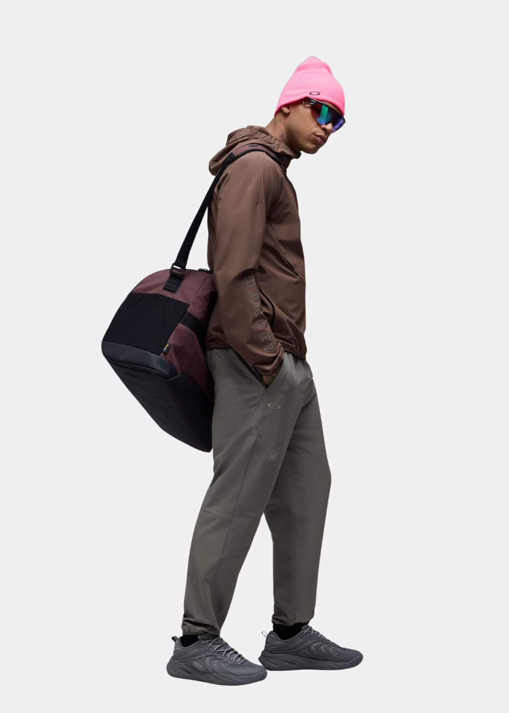 Mannequin de profil avec sac de sport portant le pantalon technique Oakley Edge Force gris