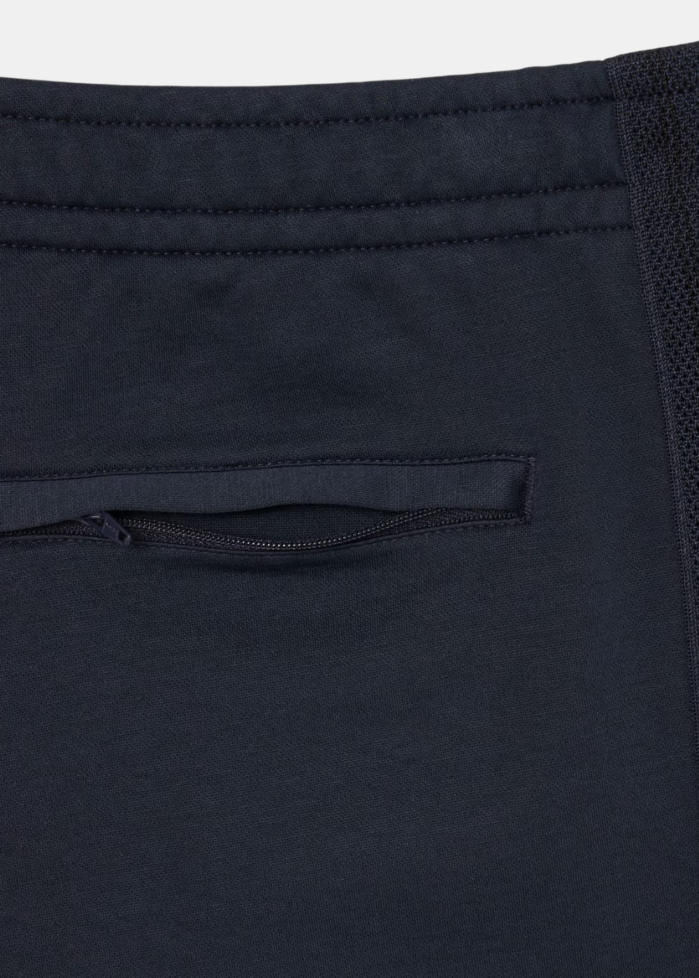 Détail de la poche arrière zippée et de la ceinture élastiquée du pantalon de survêtement marine.