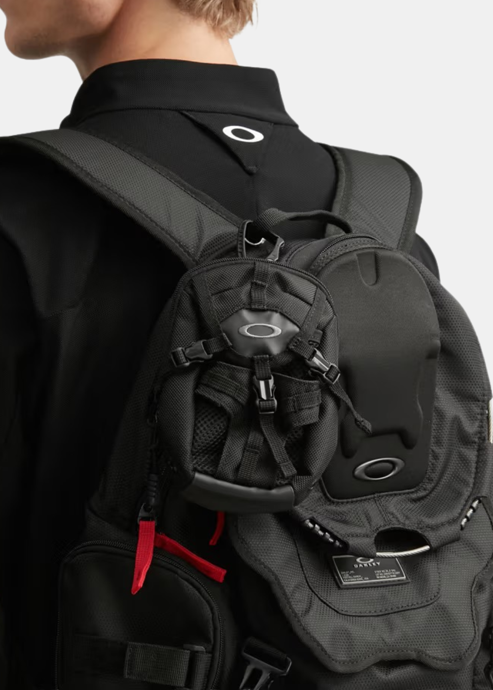 Pochette tactique Oakley noire accrochée à la bretelle d'un sac à dos grâce au mousqueton