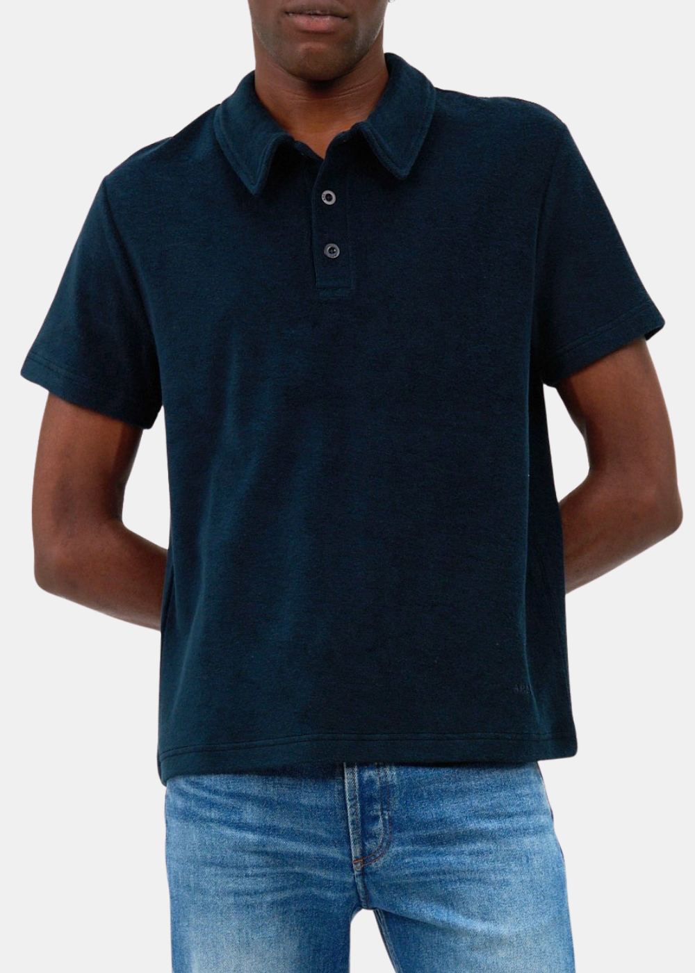 Grand plan sur le buste d'un mannequin portant le polo marin APC Julian en coton éponge, présentant le col à boutons et le logo brodé ton sur ton.