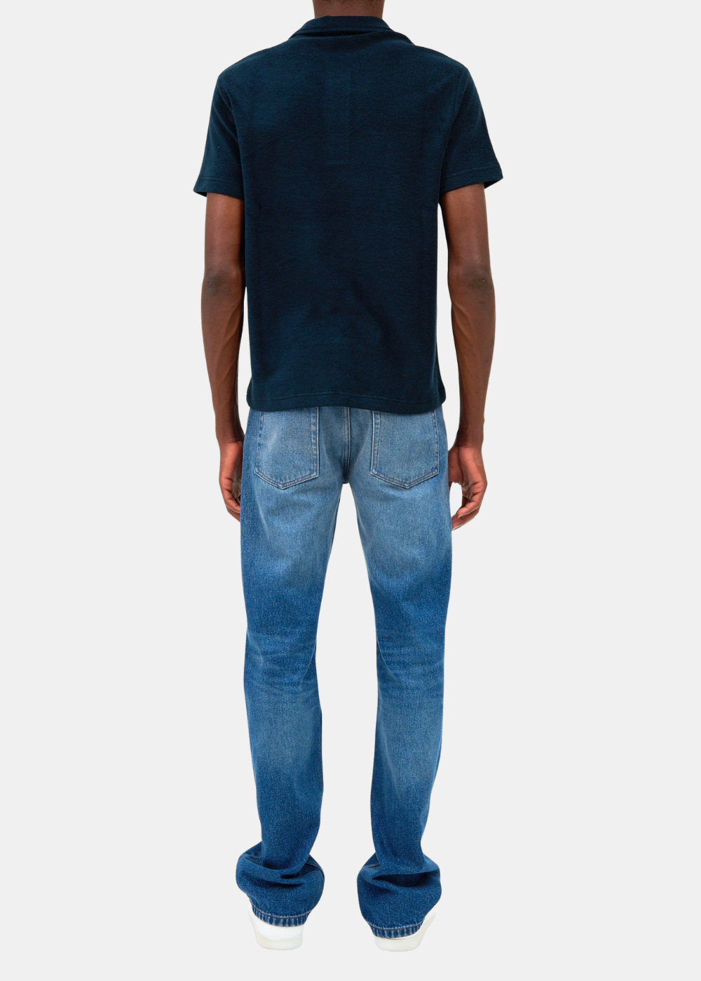 Vue de dos mannequins portant le polo marin APC Julian en coton biologique éponge, un jean bleu et des baskets blanches sur fond blanc.