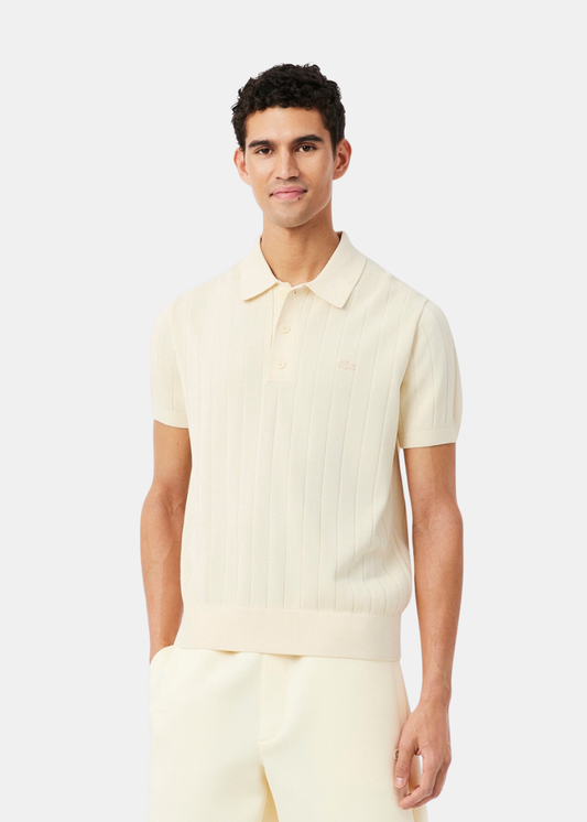 Polo beige Lacoste en maille fluide porté par un homme, mettant en avant la coupe décontractée.