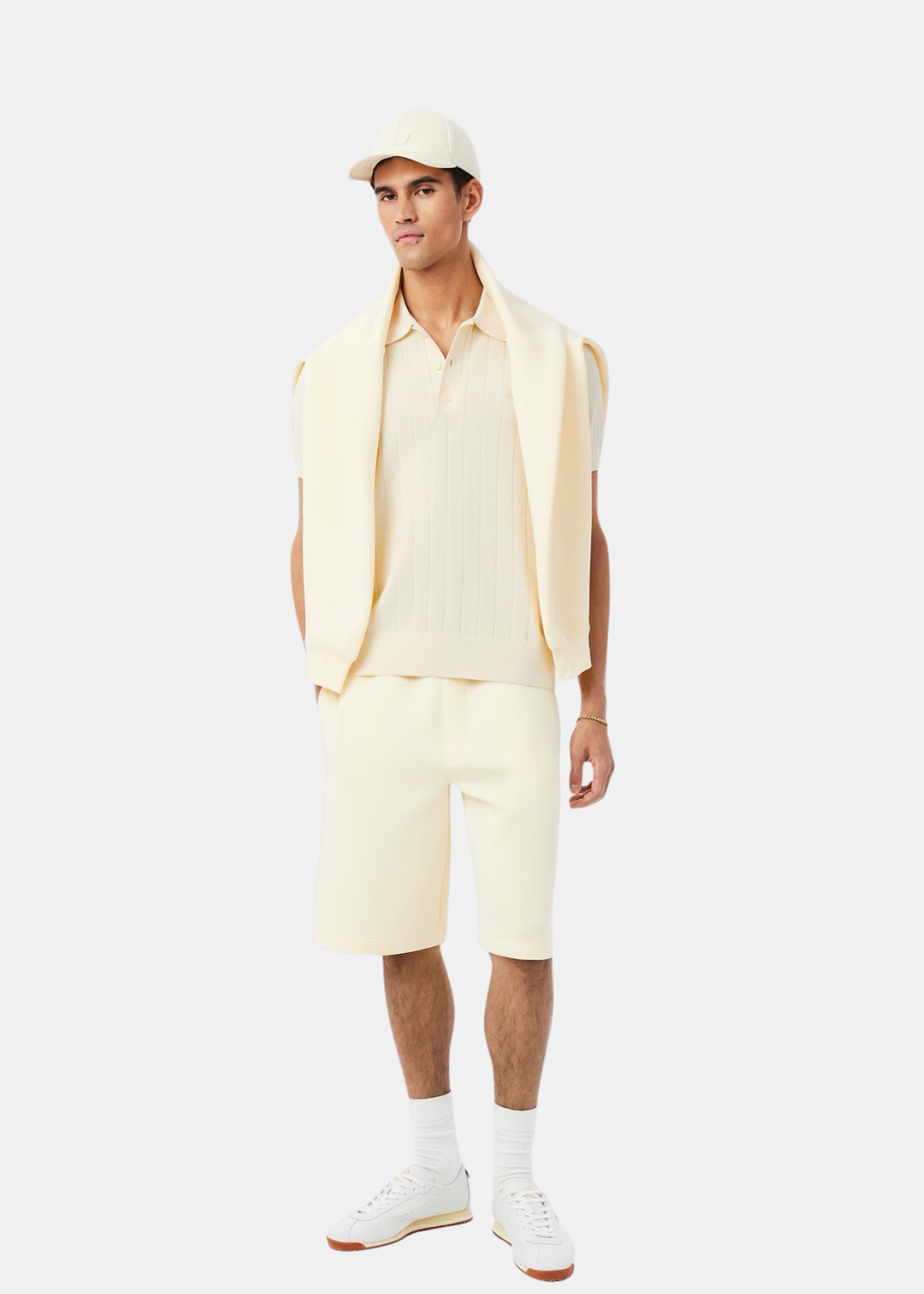 Tenue complète avec polo beige en maille côtelée,short ample marron et baskets blanches.