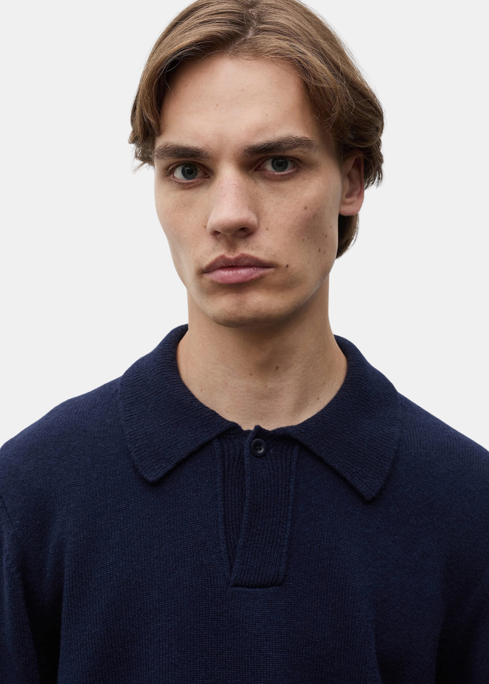 Gros plan portrait du mannequin portant le polo Norse Projects Anholt en laine marine col ouvert
