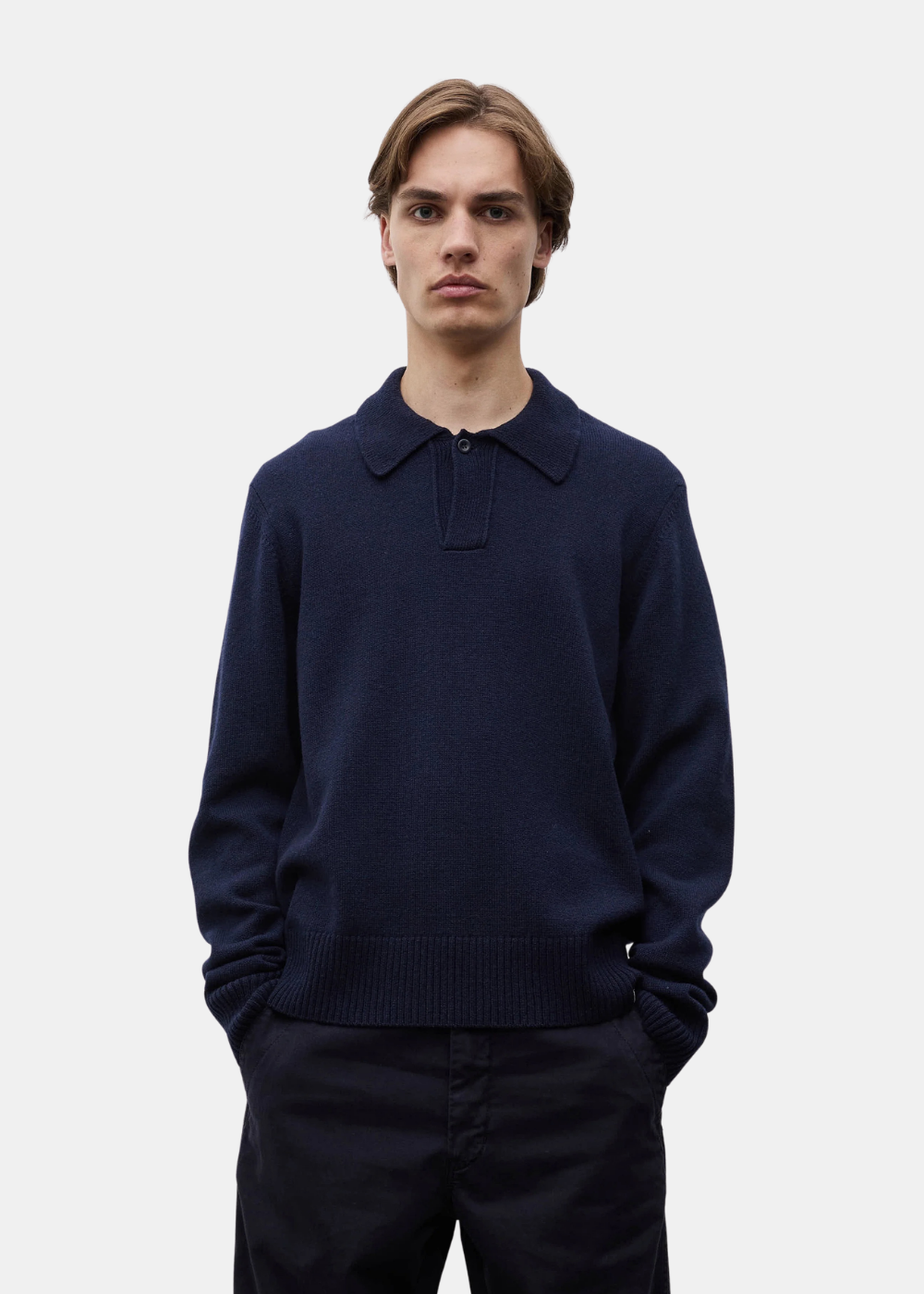 Mannequin de face les mains dans les poches portant le polo Norse Projects Anholt en laine bleu marine