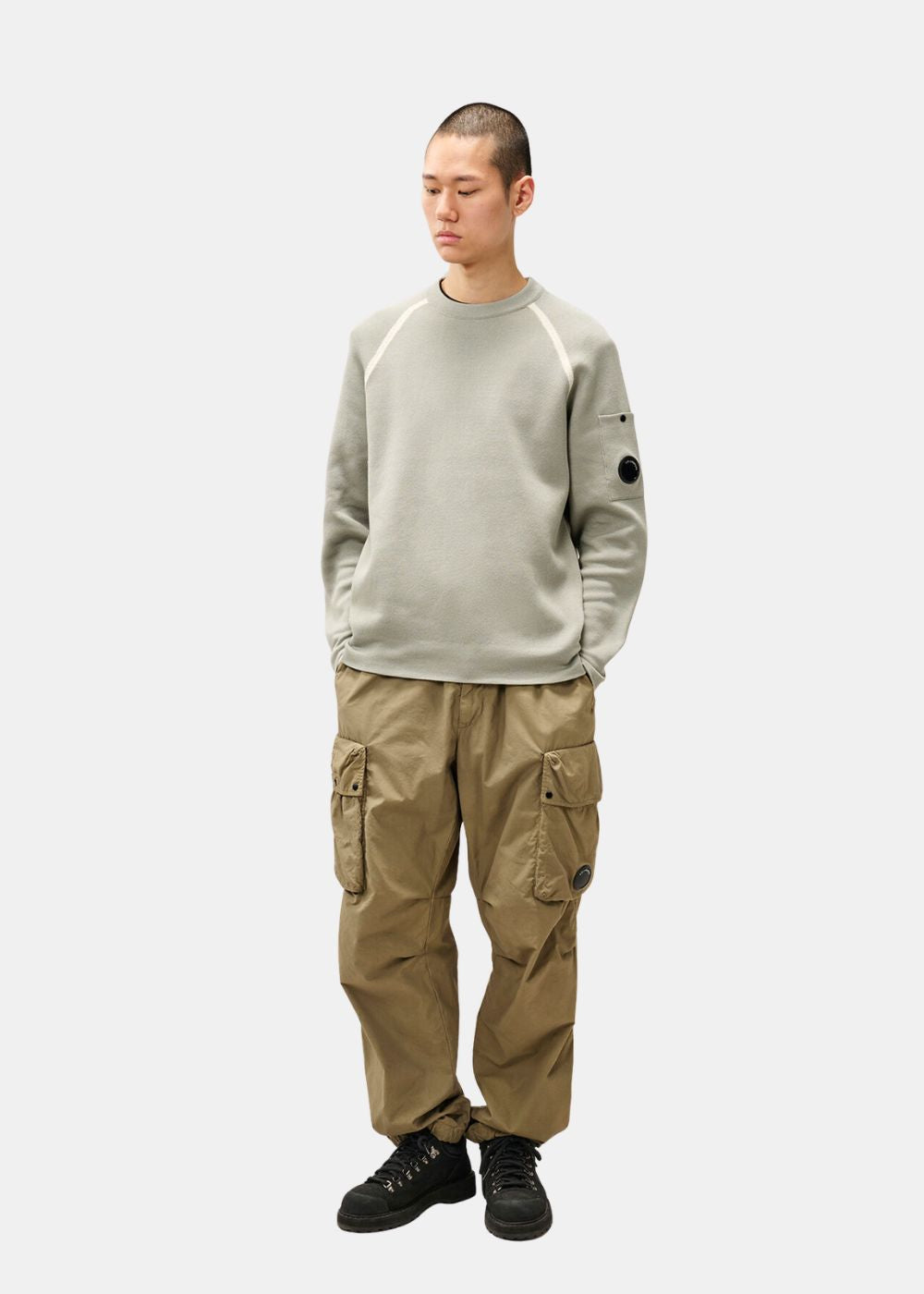Mannequin homme portant le pull en maille double C.P. Company gris sauge avec un pantalon cargo.