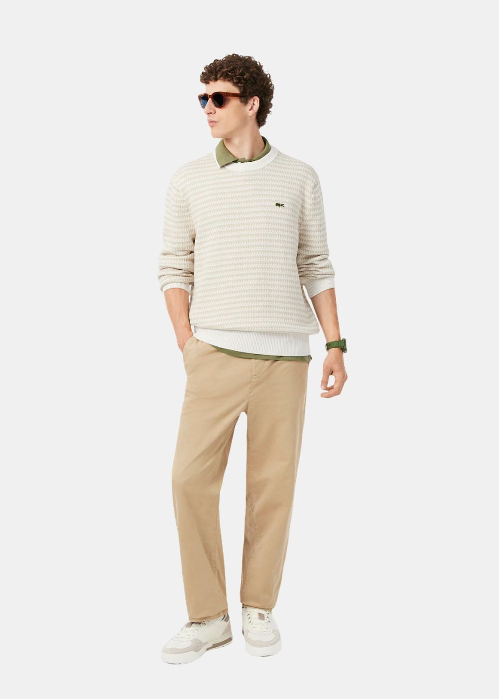 Tenue complète avec le pull Lacoste beige en maille fantaisie associé à un pantalon chino beige.