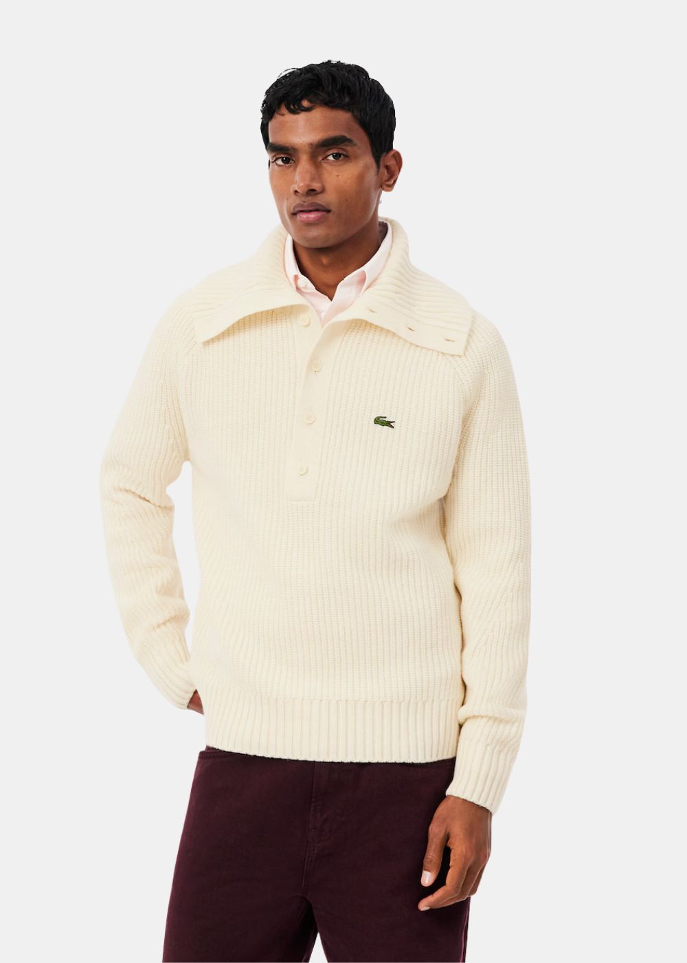 Mannequin portant le pull écru Lacoste à col montant boutonné en laine perlée.