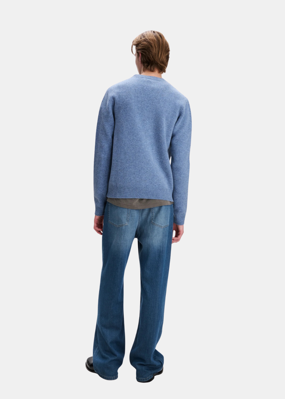 Mannequin homme vu de dos portant le pull en laine bleu chiné A.P.C., jean bleu et chaussures noires