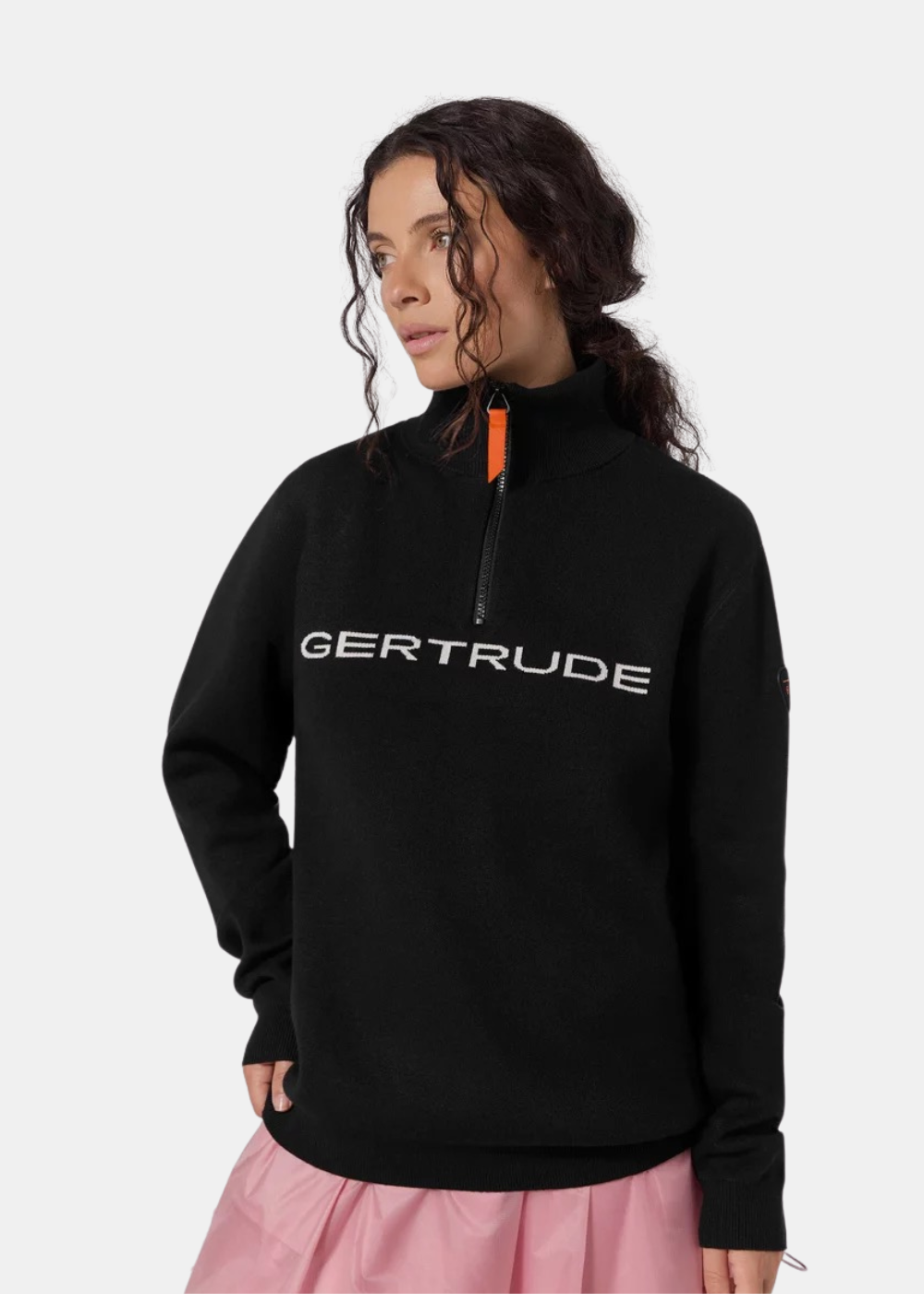 Mannequin femme de trois-quarts portant le pull camionneur unisexe noir Gertrude col semi-ouvert et jupe rose