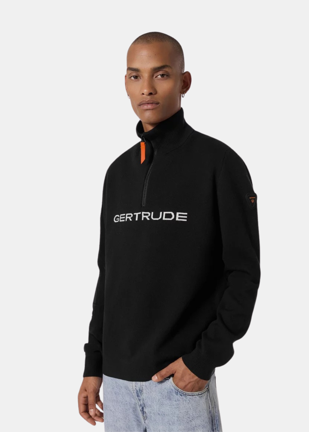 Mannequin homme de trois-quarts portant le pull camionneur noir Gertrude avec col montant zippé et jean clair