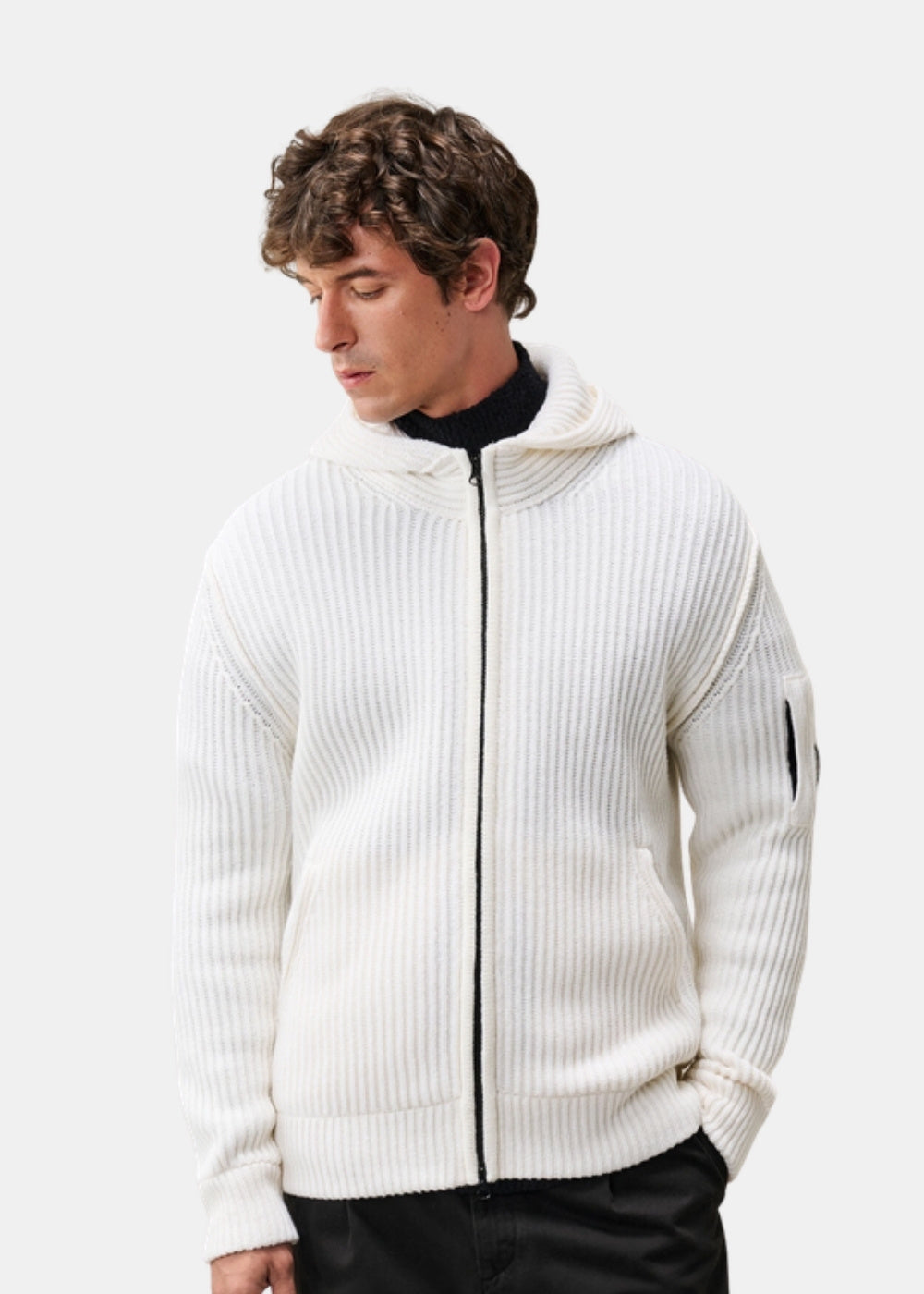 Porté de face d'un pull à capuche zippé blanc C.P. Company en maille Lambswool, col roulé noir dessous, fermeture ouverte.