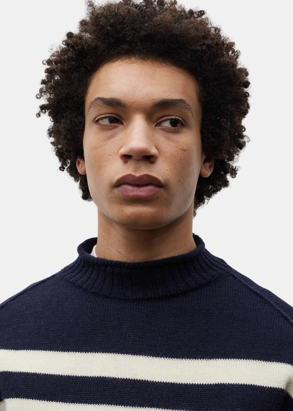 Gros plan sur le col camionneur roulé en maille du pull homme Norse Projects bleu marine et écru