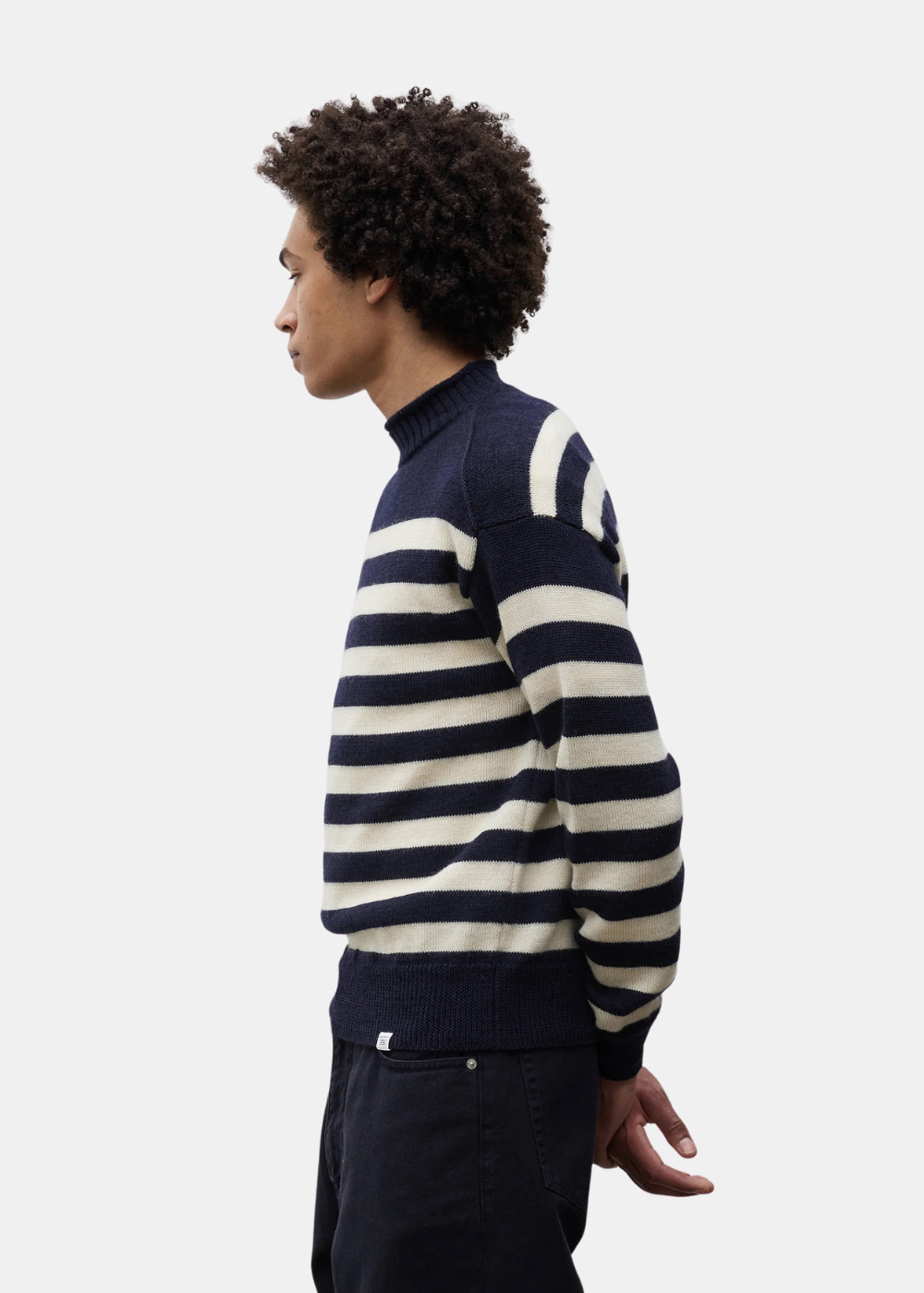 Pull col camionneur homme Norse Projects en pur lambswool rayé bleu marine et écru porté de profil
