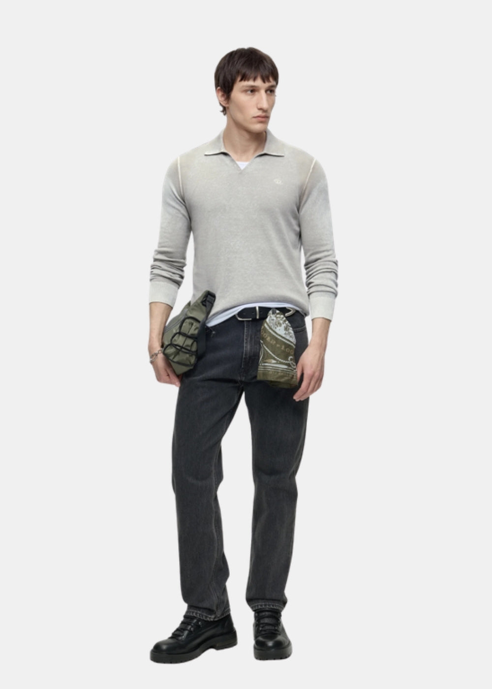 Porté en pied d'un pull beige Diesel K-Lorenzo à col polo, associé à un pantalon sombre, des chaussures noires et une sacoche.