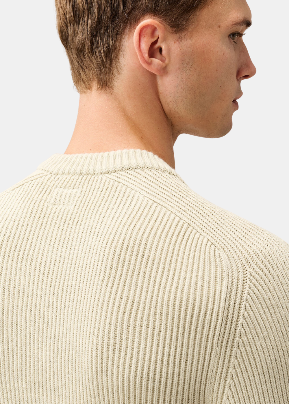 Gros plan sur l'empiècement dos et le col rond en maille anglaise du pull C.P. Company beige