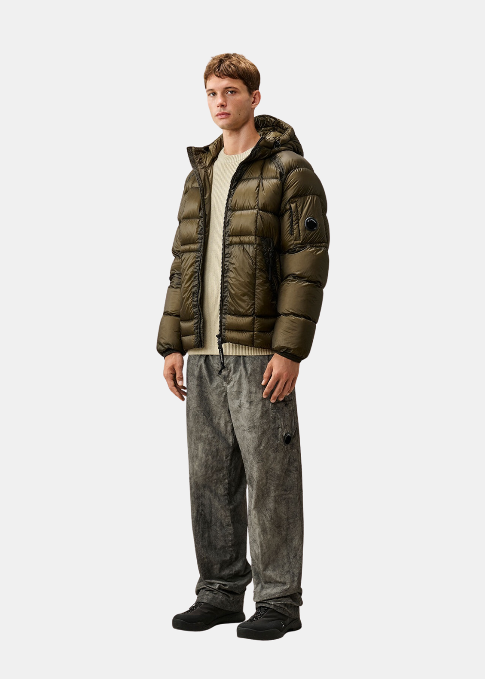 Silhouette complète portée du pull beige C.P. Company avec doudoune kaki et pantalon en velours côtelé gris