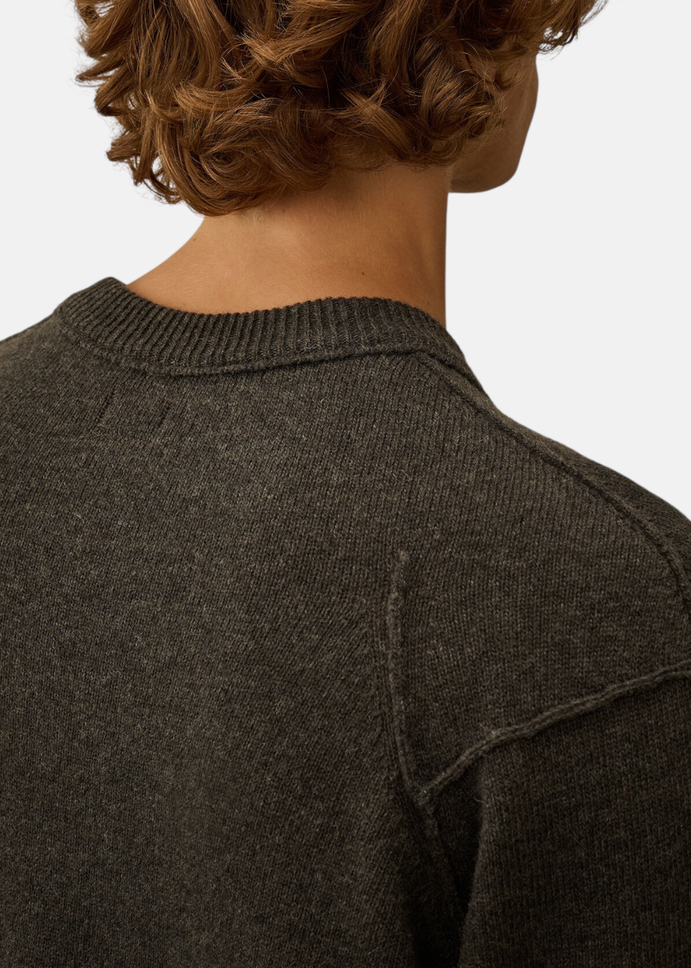 Gros plan sur le col et les épaules du pull C.P. Company Lambswool gris, montrant la maille.