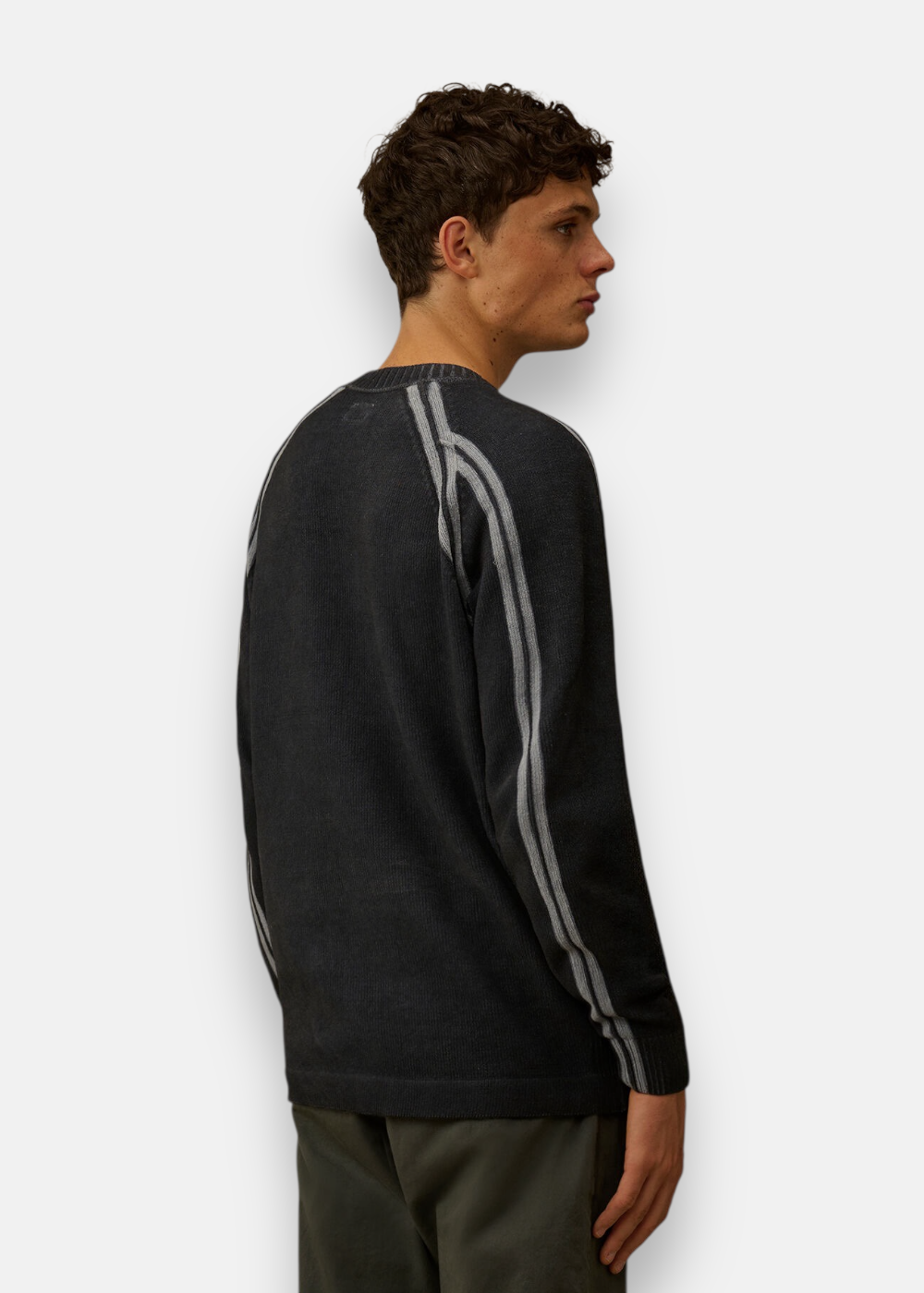 Vue de dos d'un homme portant le pull C.P. Company Navy, mettant en valeur la texture chenille et la coupe.