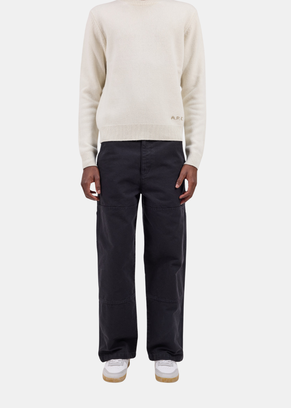 Mannequin homme en pied portant le pull Edmond A.P.C. blanc cassé avec un pantalon noir carpenter