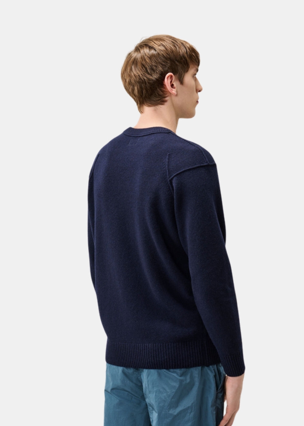 Porté de dos d'un pull marine C.P. Company en laine d'agneau montrant la coupe classique et les épaules.