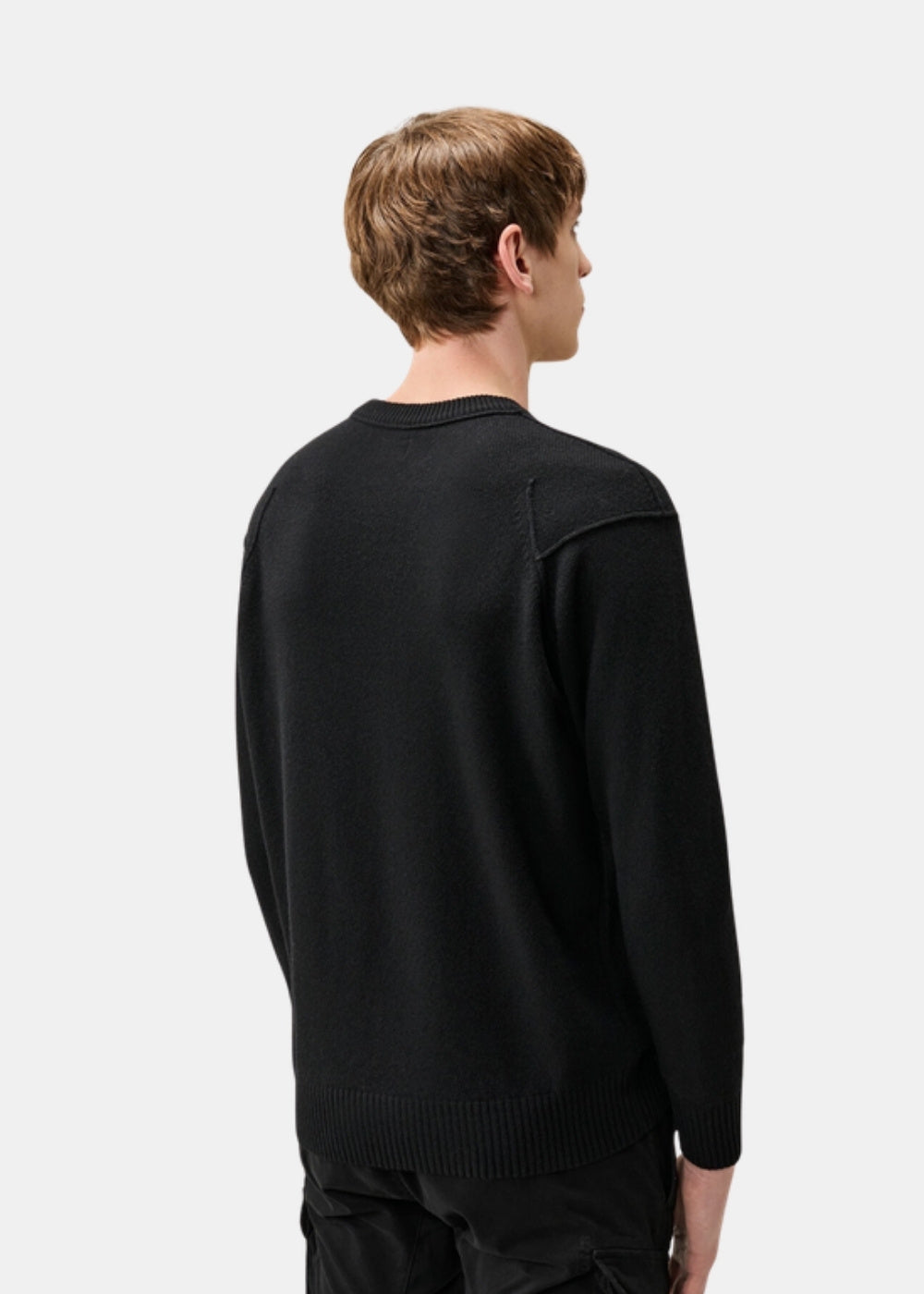 Porté de dos d'un pull noir C.P. Company en laine d'agneau, montrant la coupe classique et le col rond côtelé.
