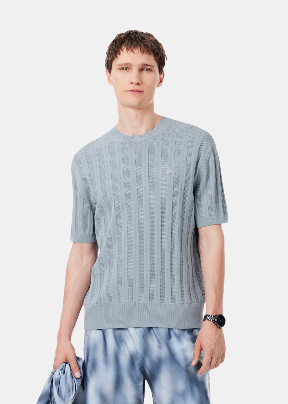 Mannequin homme de face portant le pull à manches courtes bleu clair texturé Lacoste