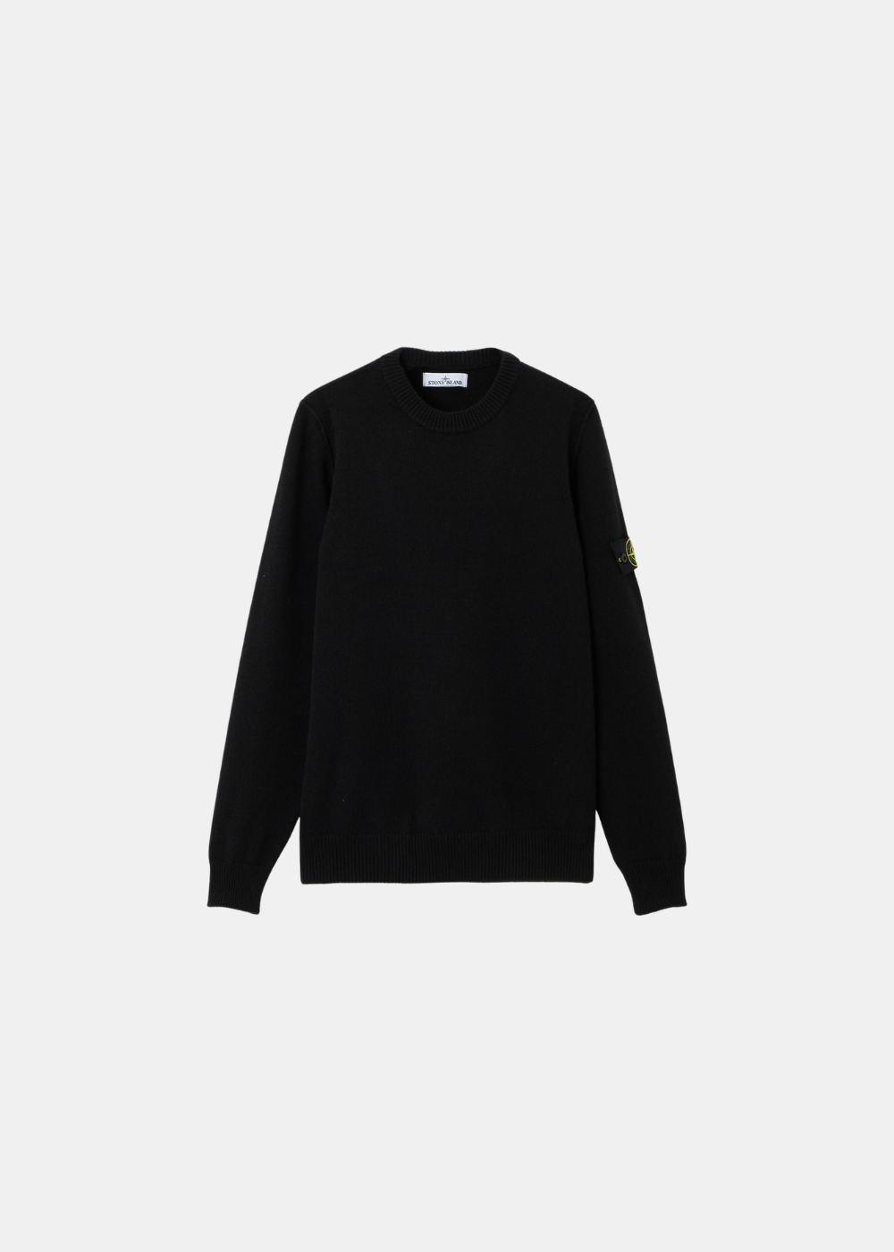 Packshot de face d'un pull noir col rond en laine d'agneau Stone Island avec son badge sur le bras gauche.