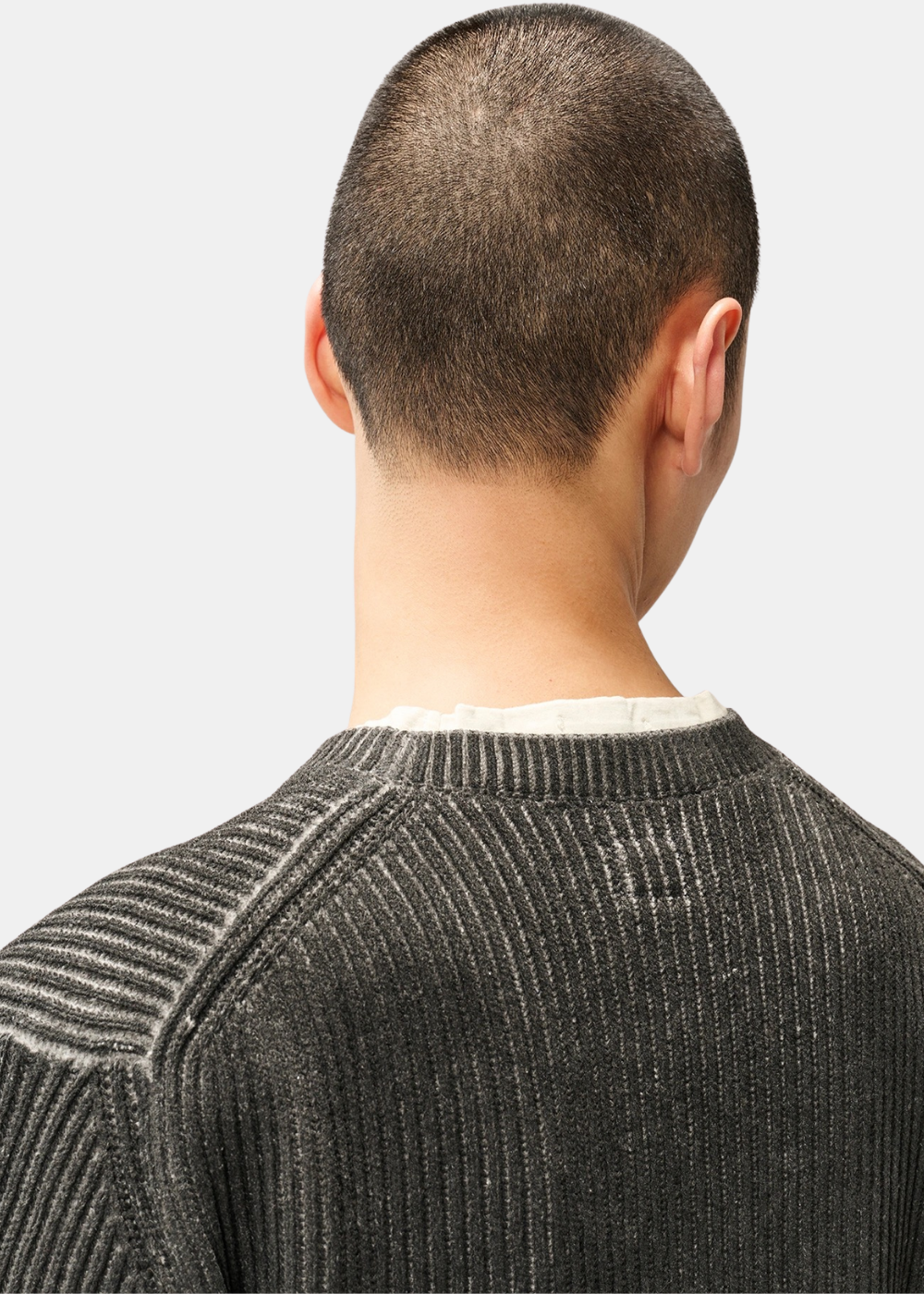 Gros plan sur l'encolure ras-de-cou et les coutures d'emmanchure du pull en maille chenille gris vue de dos