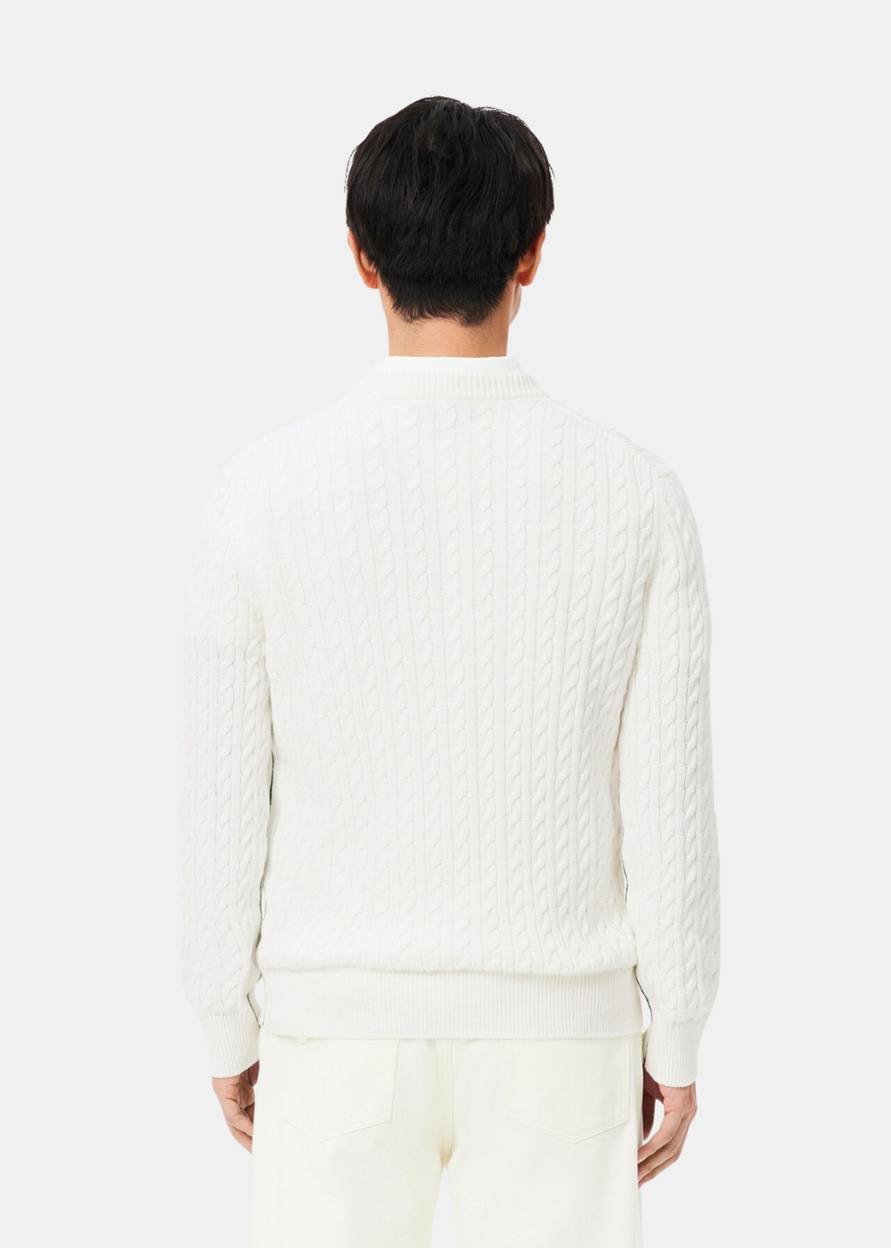 Mannequin homme vu de dos portant le pull torsadé blanc écru Lacoste avec un pantalon assorti