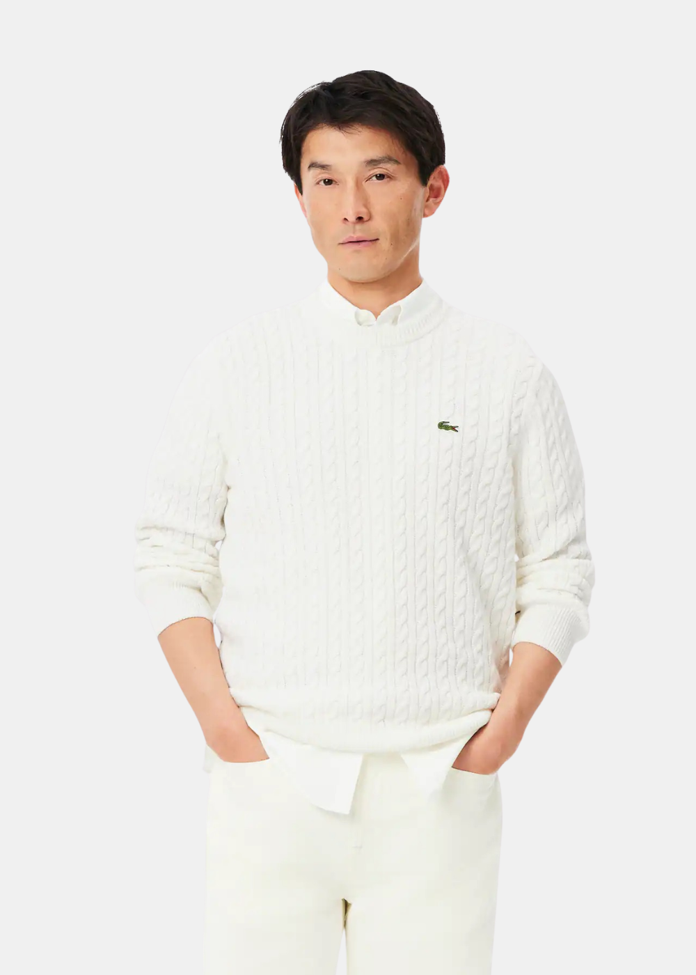 Mannequin homme de face portant le pull en maille torsadée blanc écru Lacoste sur une chemise blanche