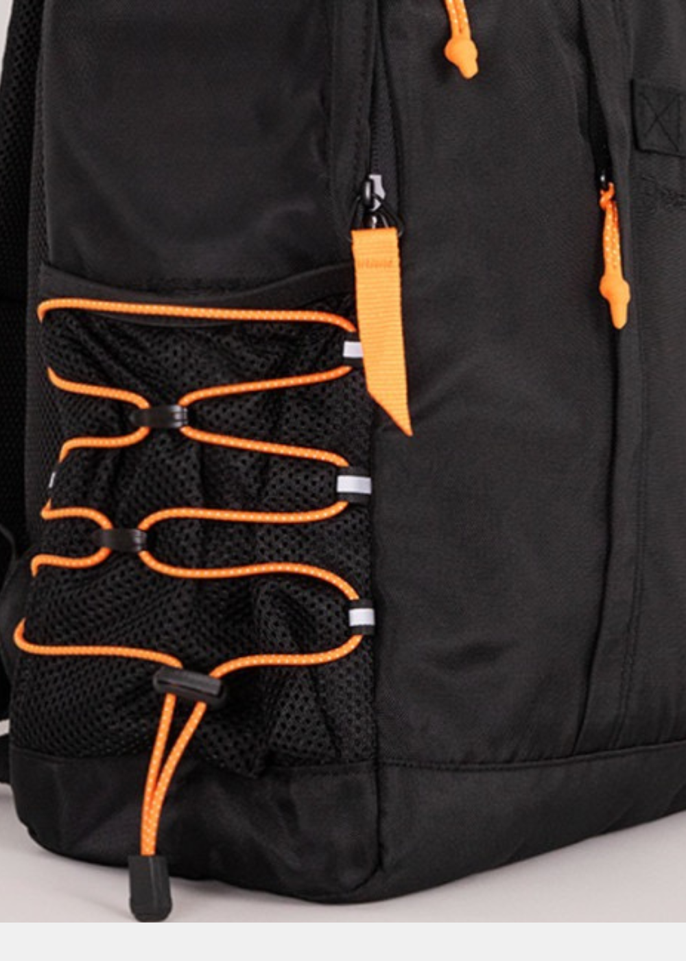 Gros plan sur la poche latérale en filet à cordons de serrage orange et les tirettes de zip du sac à dos Gertrude