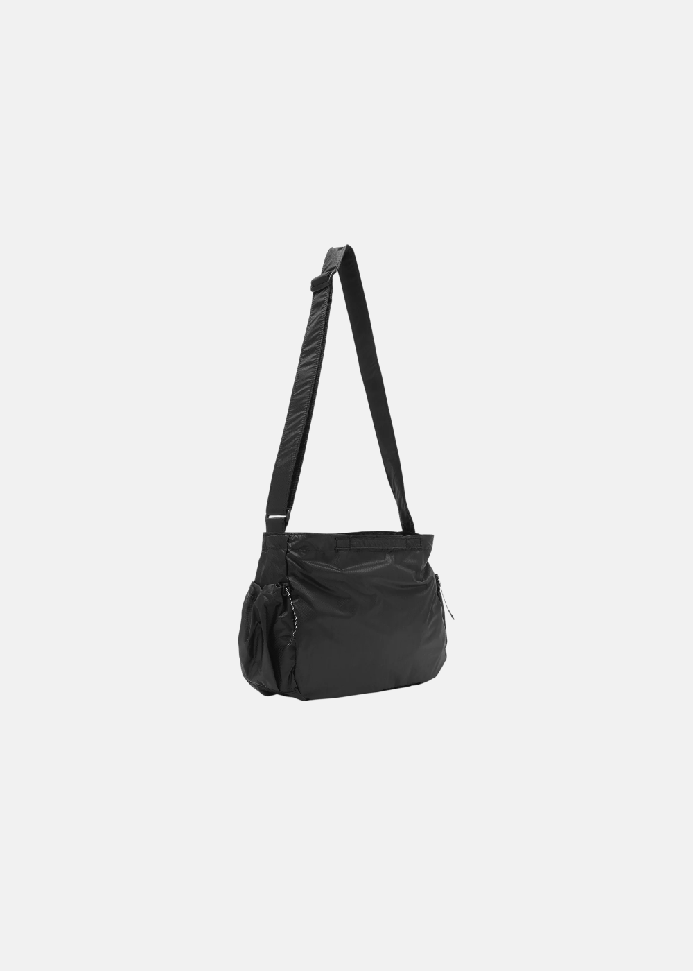 Vue de profil gauche du sac bandoulière noir And Wander, montrant la sangle réglable et la poche latérale