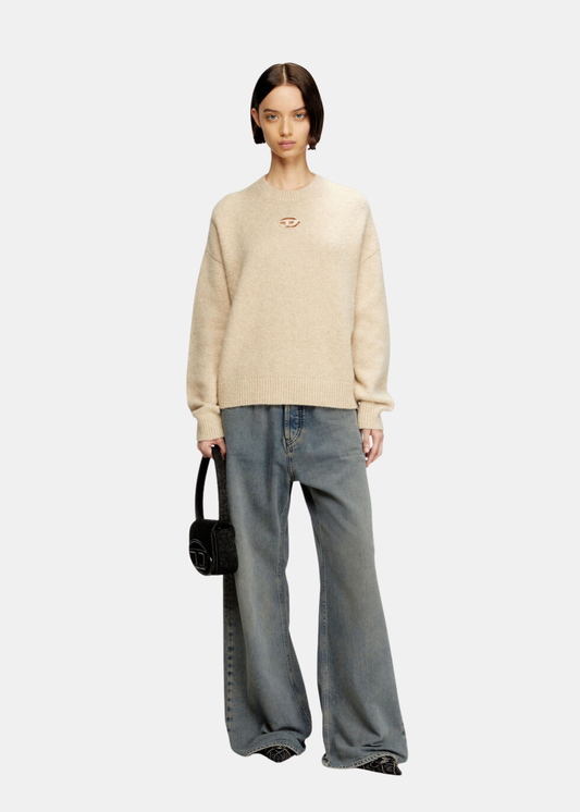 le mannequi porte une tenue diesel avec un pull en maille et le sac 1dr en denim