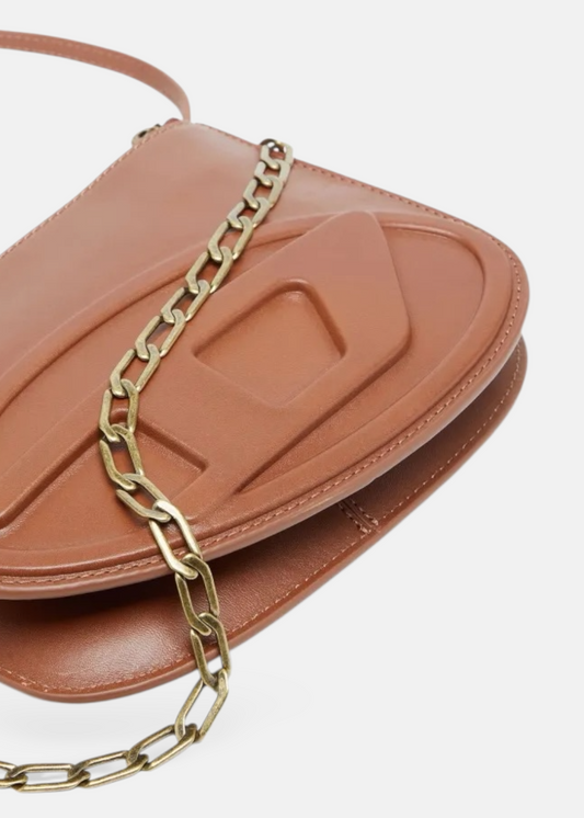 Gros plan sur le logo Oval D oversize embossé directement dans le cuir marron du sac Diesel 1DR Twin.