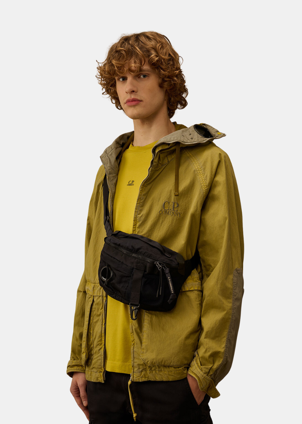 vue de face de la sacoche banane cp company en nylon noir portée en bandouliere par un mannequin