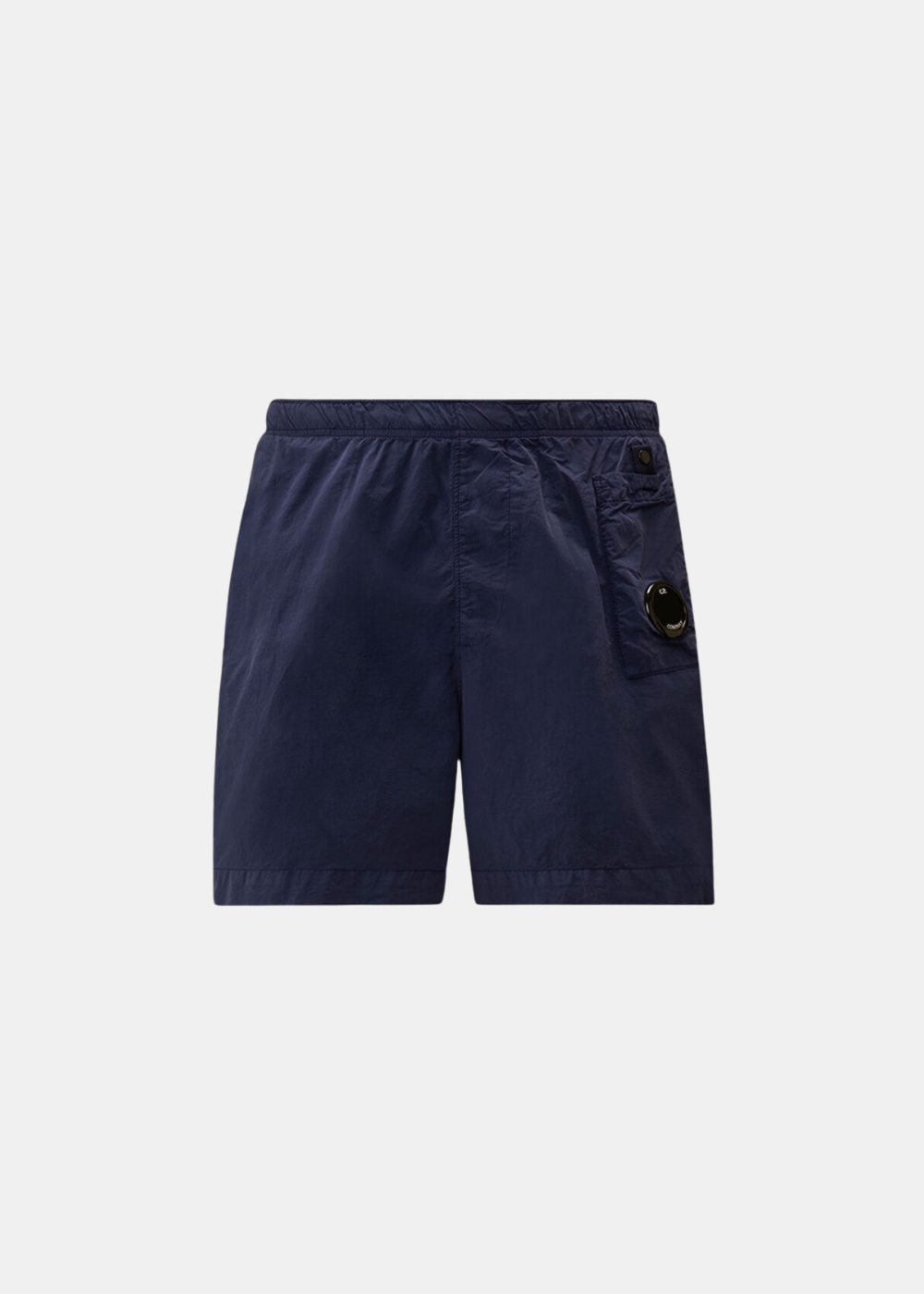Packshot de face sur fond gris d'un short de bain homme C.P. Company en nylon mat Flatt bleu marine, avec une poche cargo asymétrique sur la jambe ornée du verre de lunette (Lens) signature