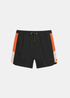 Vue de face du short de bain Gertrude Samy noir et orange avec cordon de serrage et logo triangulaire