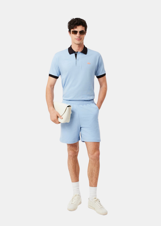 Silhouette complète avec short bleu clair Lacoste, t-shirt assorti et baskets sur un mannequin