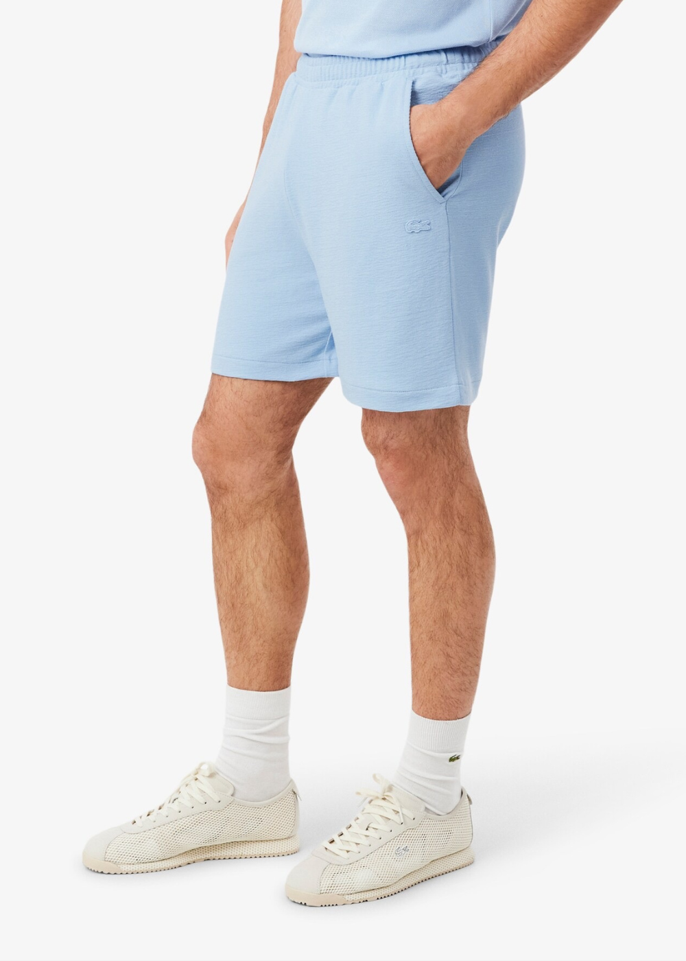 Short pour homme en jersey bleu clair Lacoste avec logo crocodile, porté de face par un mannequin