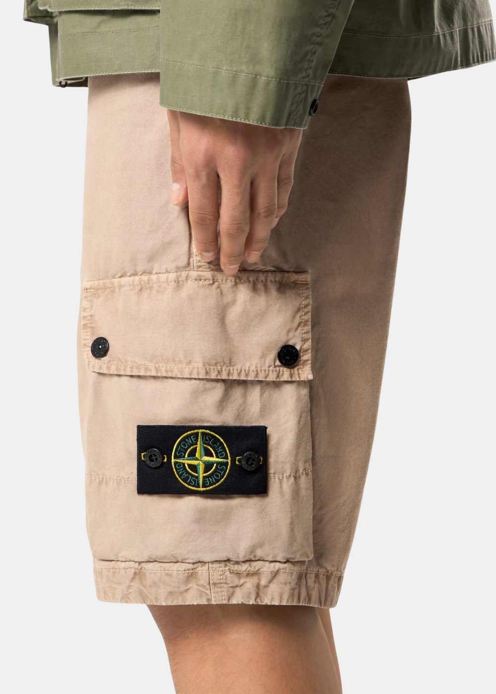 Zoom sur la poche latérale du short cargo beige Stone Island laissant apparaître le badge boussole emblématique.