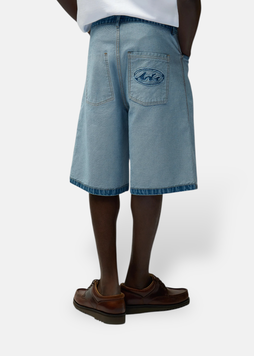 Dos d'un short en denim bleu clair inversé Arte Antwerp avec logo vieilli sur la poche arrière.