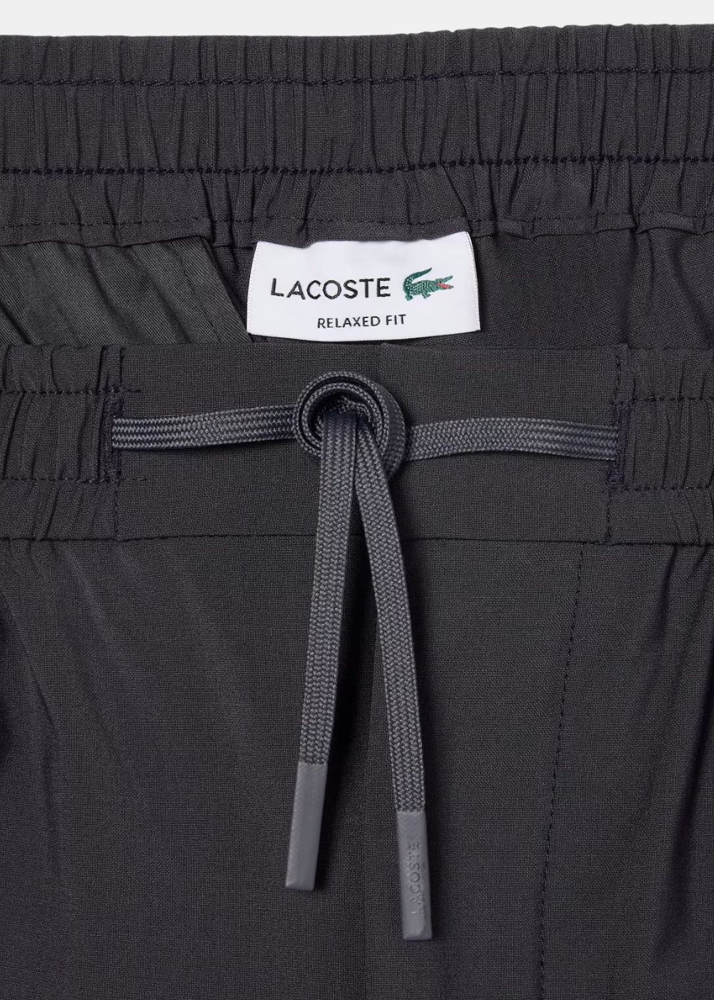 ue rapprochée de la taille élastique avec cordon de serrage et étiquette Lacoste Relaxed Fit apparente.