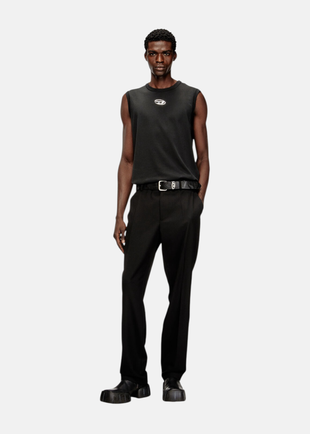 Mannequin portant le débardeur ajusté Diesel avec un pantalon noir et une ceinture à boucle logo.