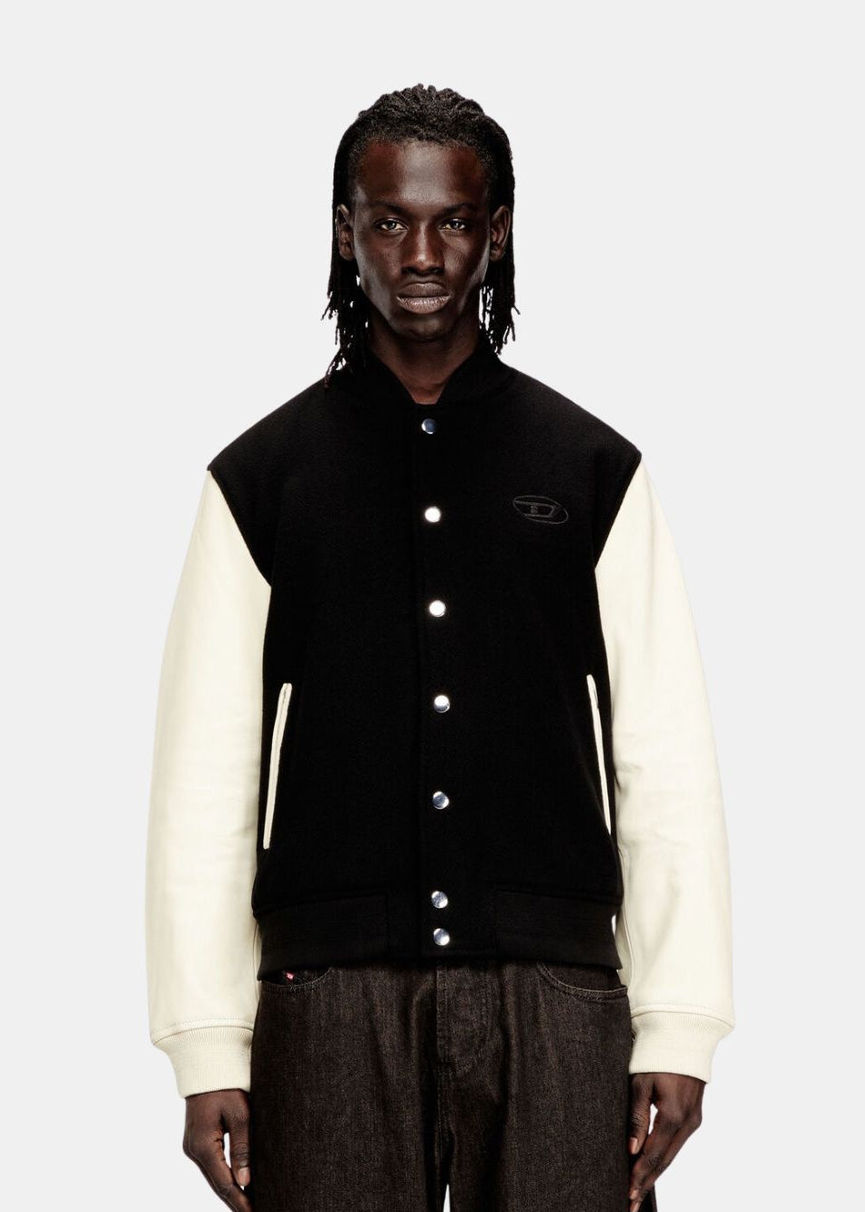 Silhouette complète avec le blouson Diesel porté ouvert sur un t-shirt blanc et un jean large.