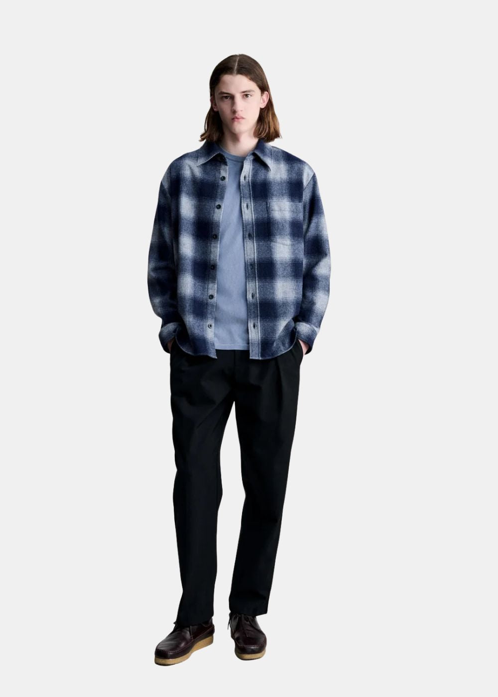 Mannequin homme portant la surchemise en laine A.P.C. Malaury ouverte sur un t-shirt bleu et un pantalon noir.