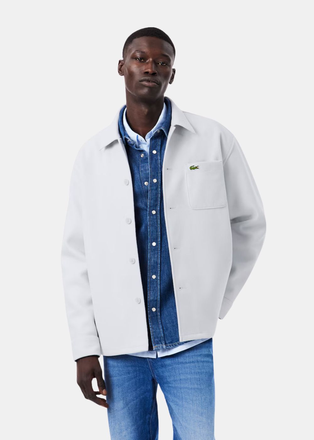 Mannequin portant la surchemise Lacoste gris clair en flanelle ouverte sur une chemise en jean.