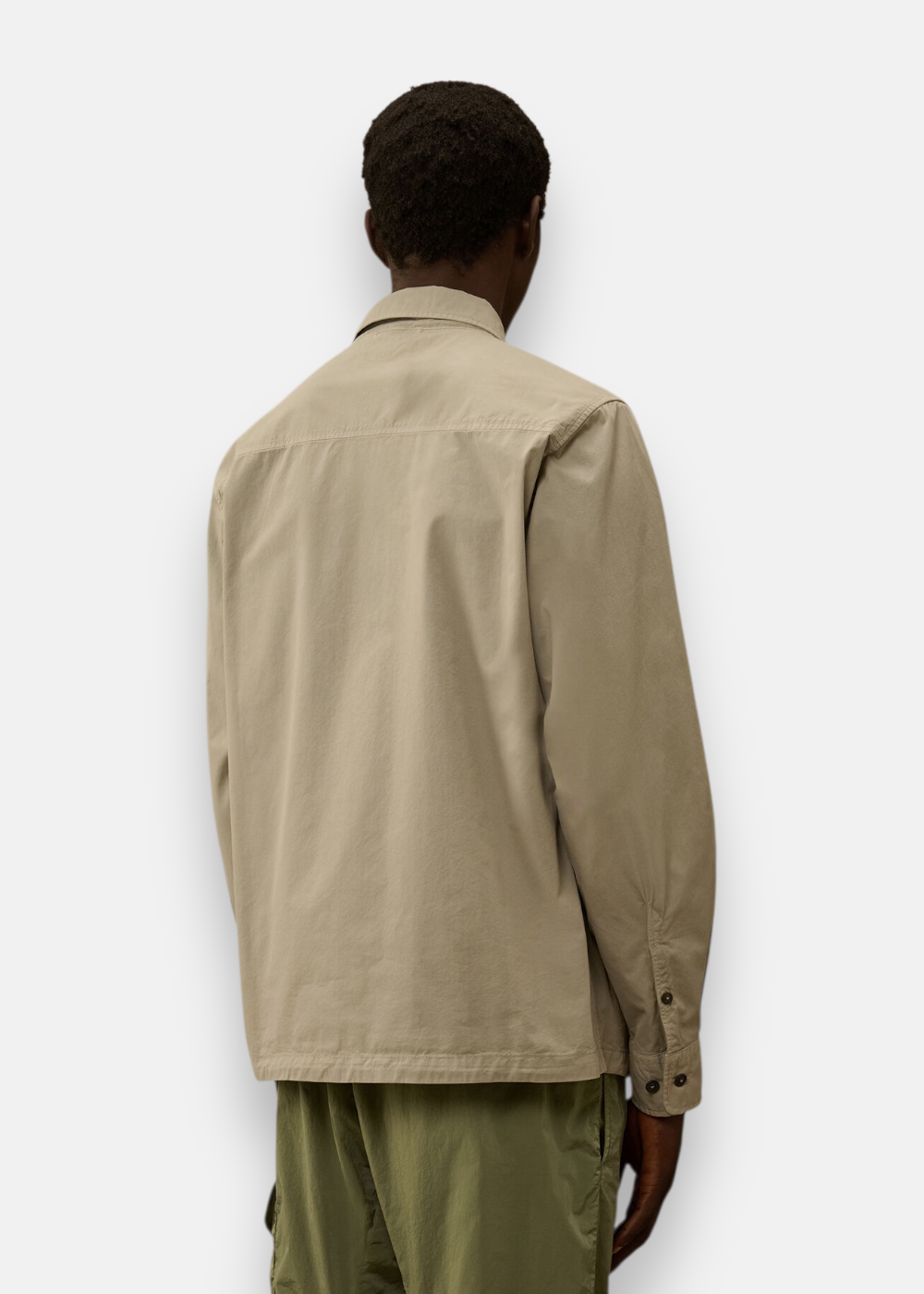 Gros plan sur le dos et le col de la surchemise C.P. Company en gabardine gris clair.
