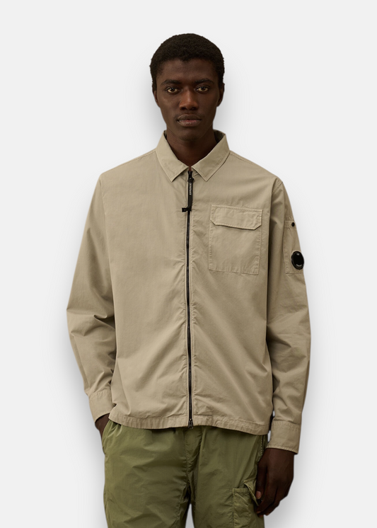 Homme portant la surchemise C.P. Company zippée gabardine beige, vue de face.